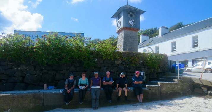 A group of people posing for a photo in front of a clock tower

Description automatically generated