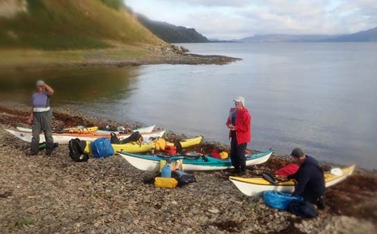 A group of people standing next to kayaks on a rocky shore

Description automatically generated with low confidence