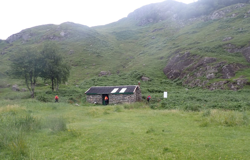 A stone building in a grassy area

Description automatically generated