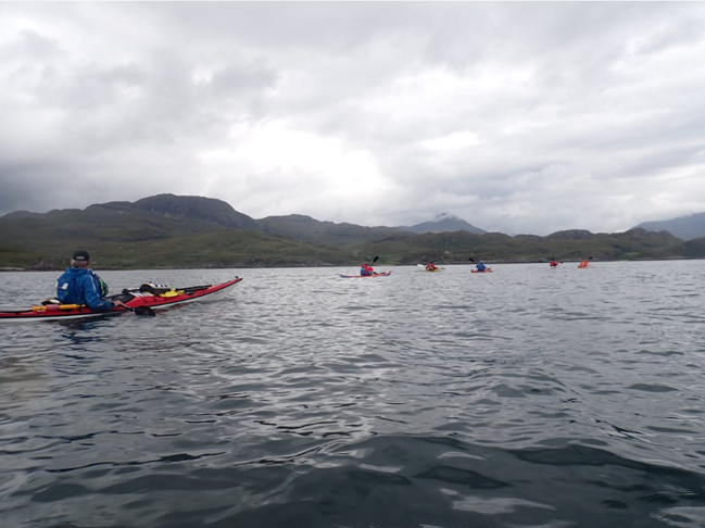A group of people kayaking in a lake

Description automatically generated