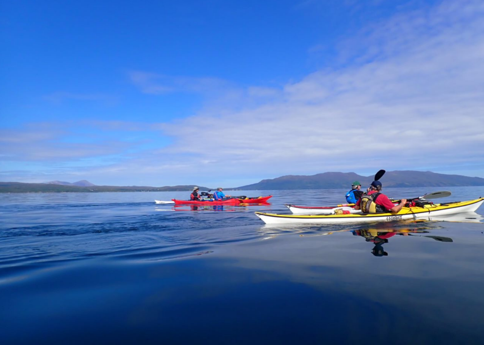 A group of people in kayaks on a lake

Description automatically generated