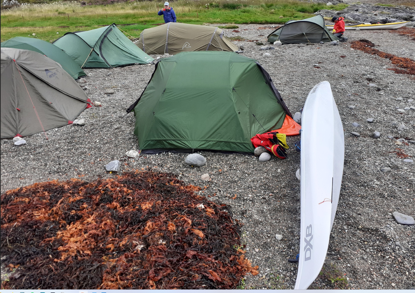 A group of tents on a rocky beach

Description automatically generated