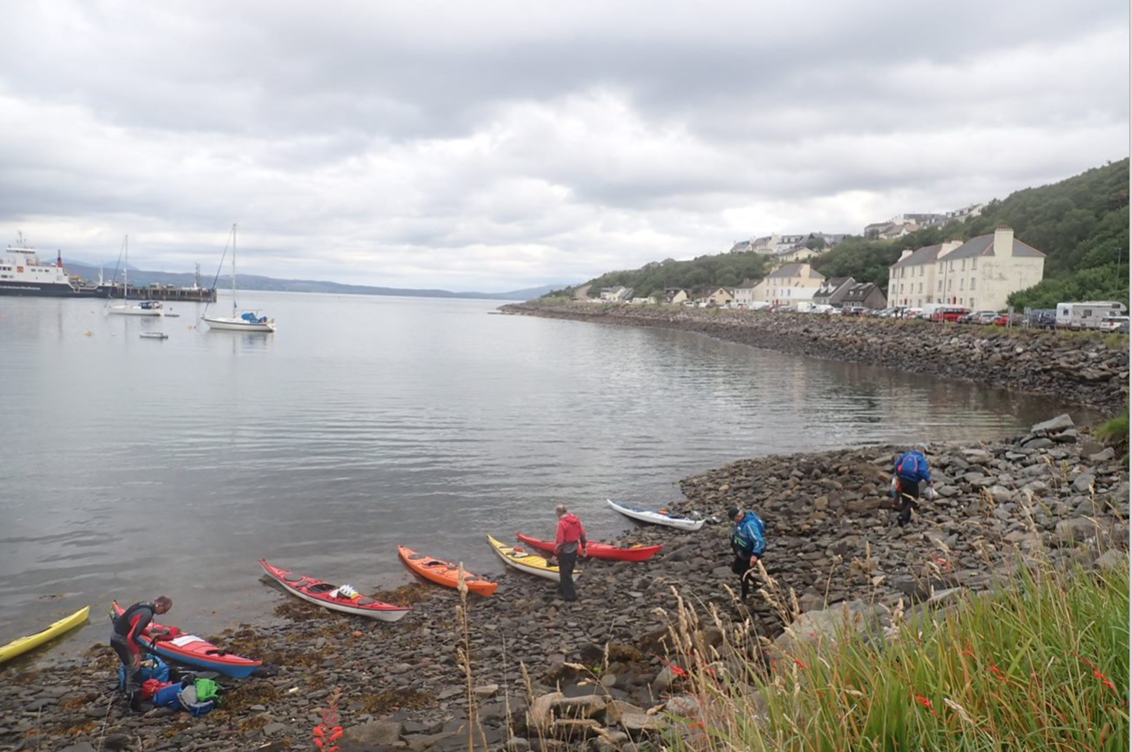A group of people with kayaks on a rocky shore

Description automatically generated