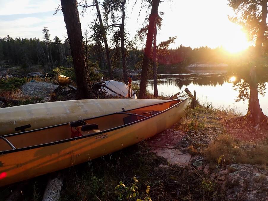 A canoe on the shore of a lake

Description automatically generated