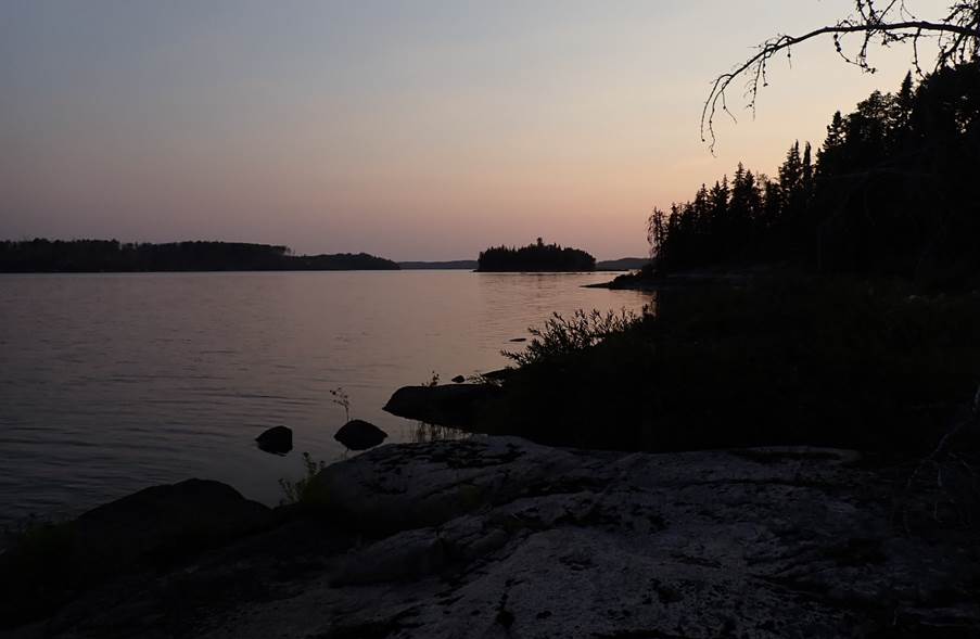 A body of water with trees and rocks

Description automatically generated