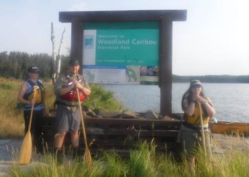 A group of people standing in front of a sign

Description automatically generated