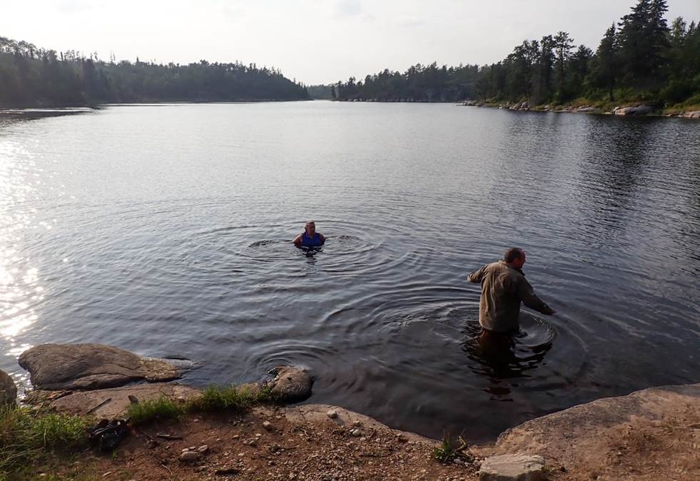 A person and person in a lake

Description automatically generated