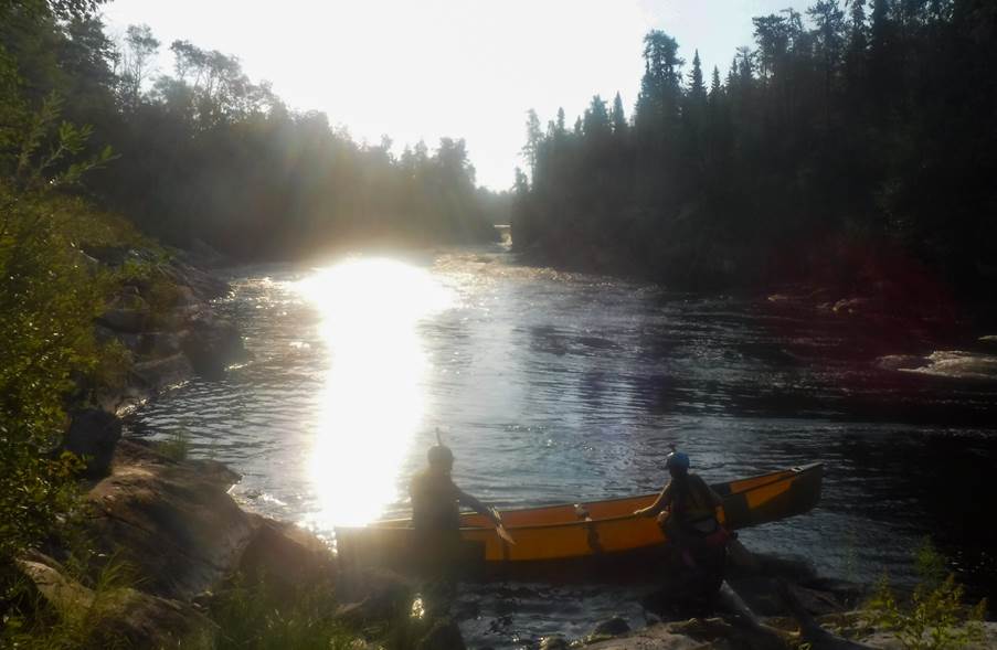 A group of people in a canoe on a river

Description automatically generated