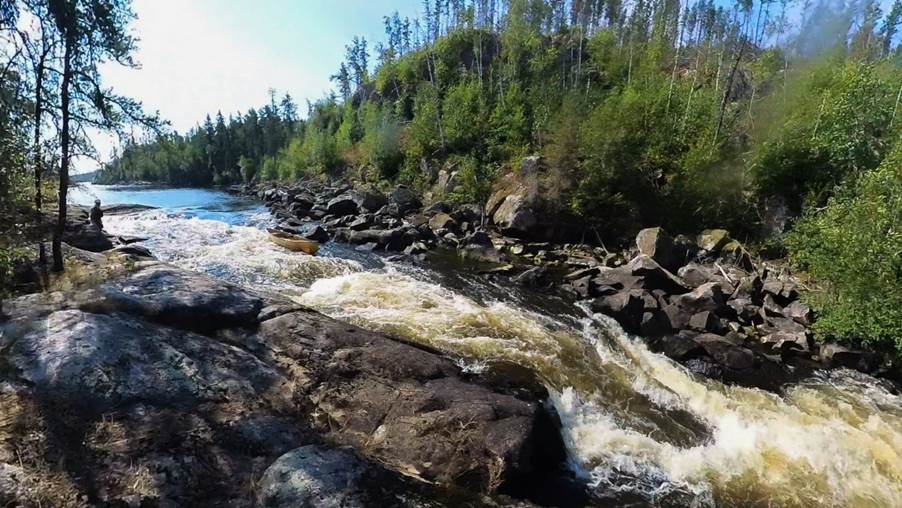 A river flowing through rocks and trees

Description automatically generated