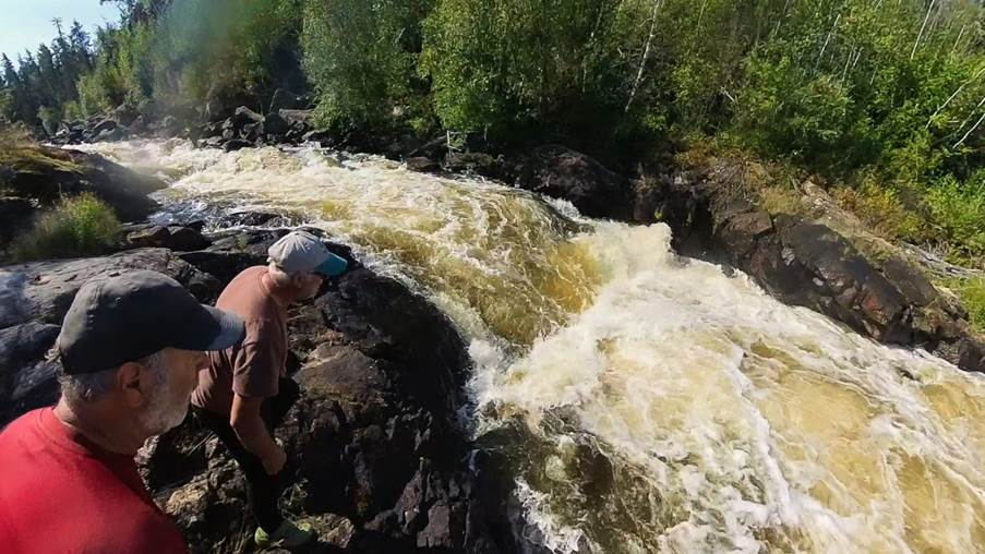 A person standing on rocks near a river

Description automatically generated