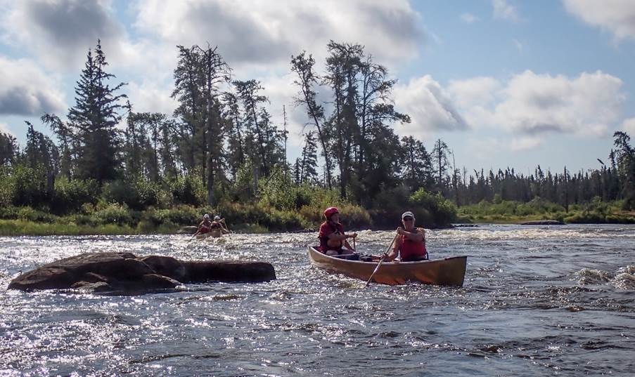 A group of people in a canoe

Description automatically generated