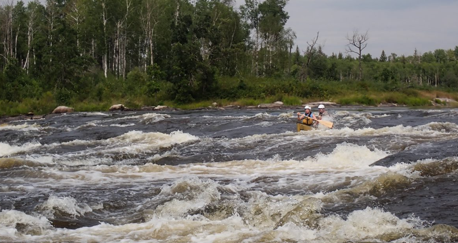 People in a canoe in a river

Description automatically generated