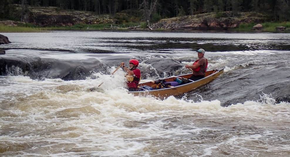 A group of people in a canoe

Description automatically generated