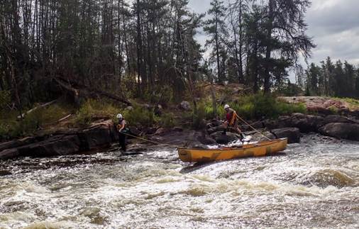 A group of people in a canoe

Description automatically generated