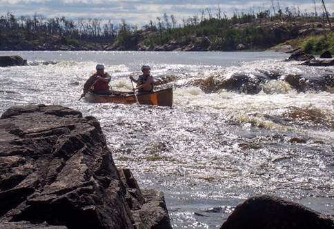 A couple of people paddling a canoe

Description automatically generated