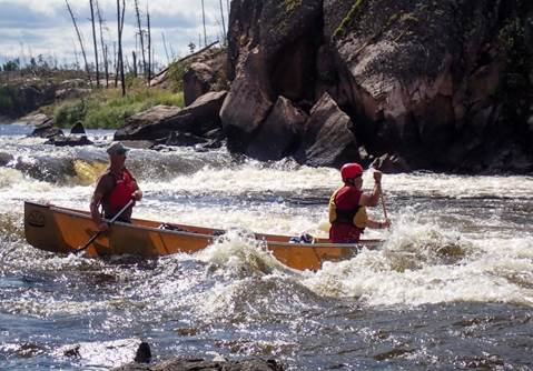 A couple of people in a canoe

Description automatically generated