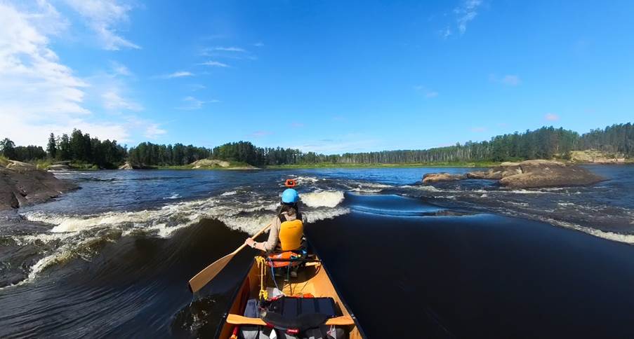 A person in a canoe on a river

Description automatically generated