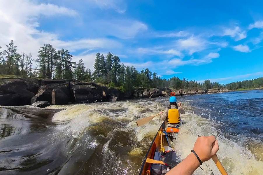 A person in a canoe on a river

Description automatically generated