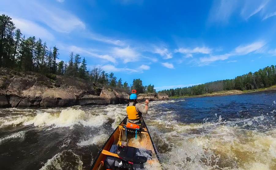 A group of people in a canoe on a river

Description automatically generated