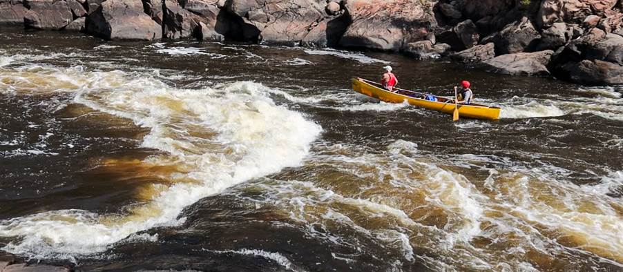 A person in a canoe on a river

Description automatically generated