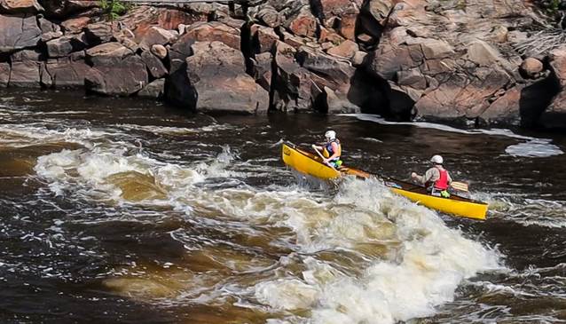 A group of people in a canoe on a river

Description automatically generated