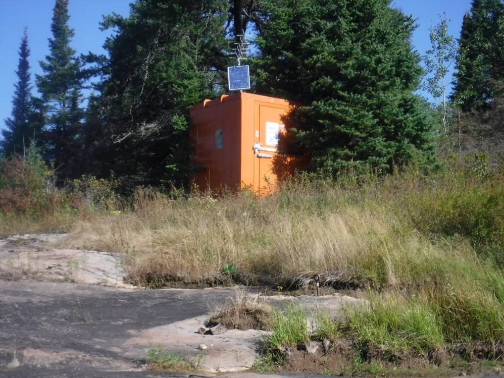 A small orange box in a grassy area

Description automatically generated