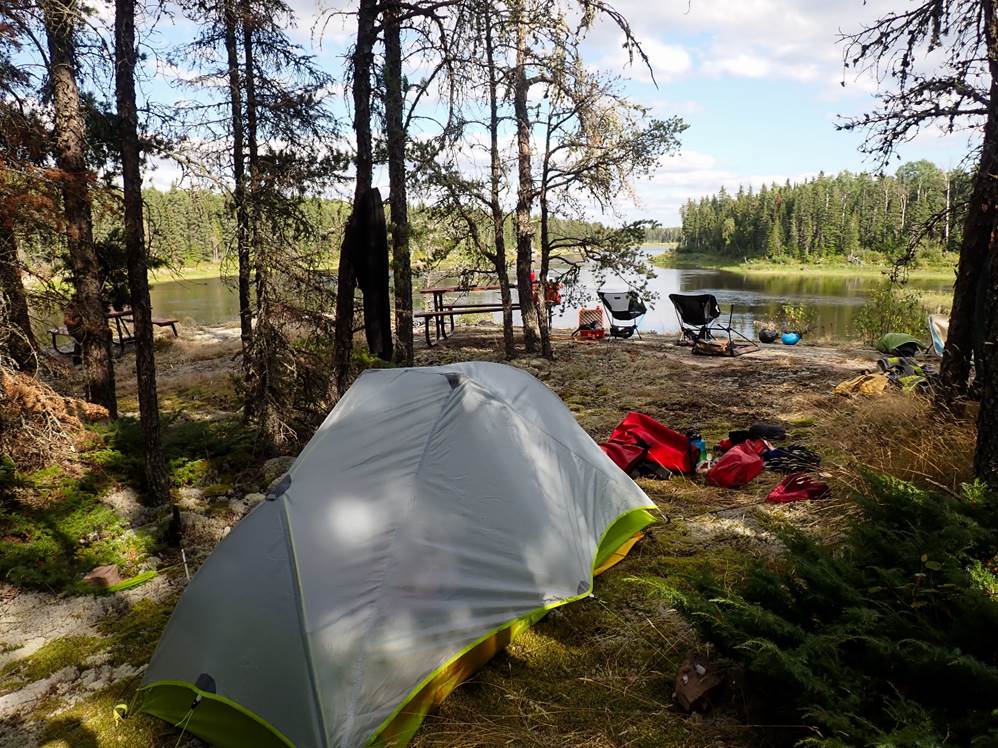 A tent next to a lake

Description automatically generated