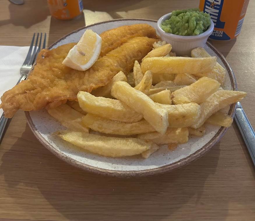 A plate of food with a lemon wedge and fries

Description automatically generated