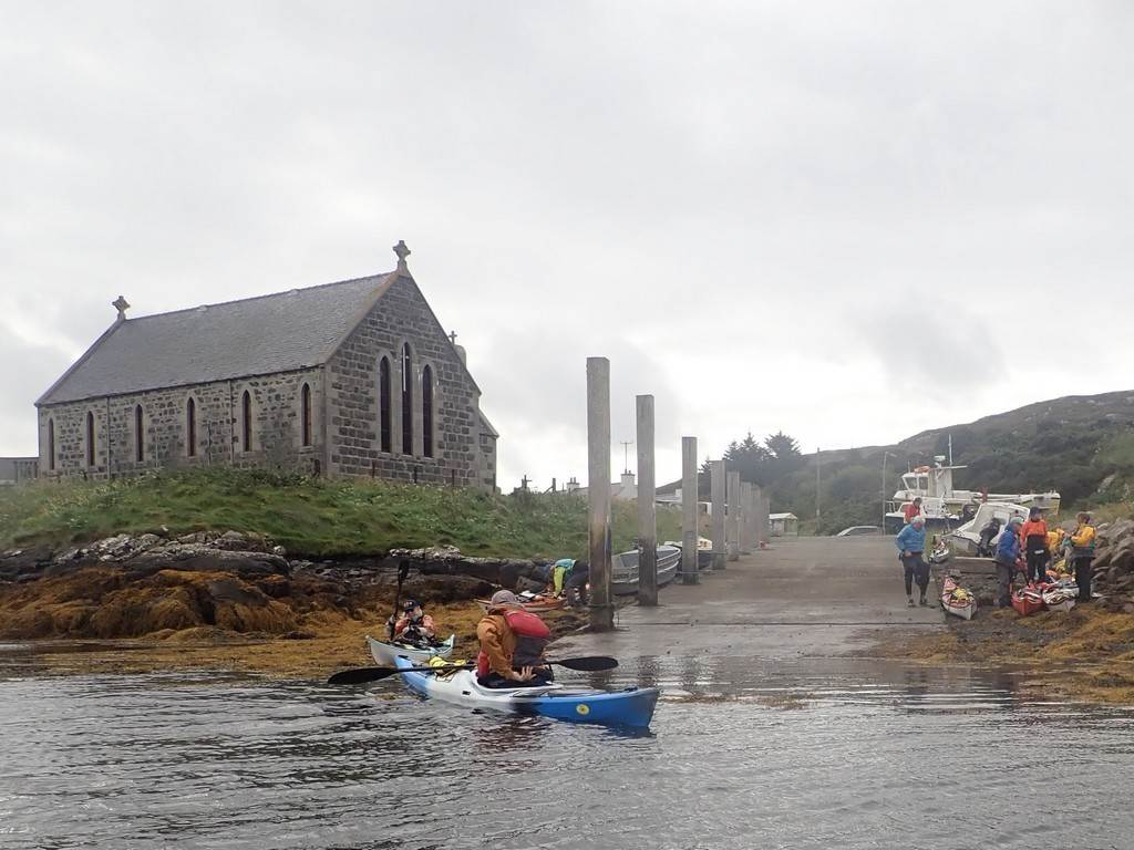 A group of people in kayaks on a body of water

Description automatically generated
