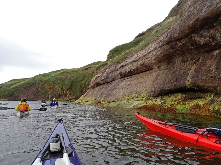 A group of people kayaking in a river

Description automatically generated