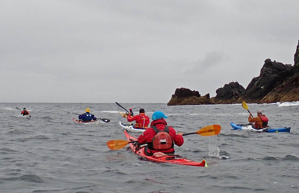 A group of people kayaking in the ocean

Description automatically generated