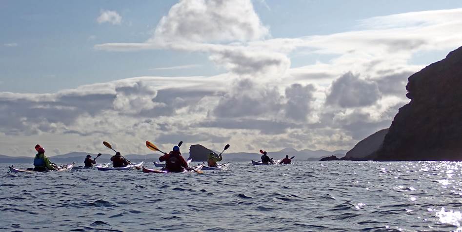 A group of people kayaking in the ocean

Description automatically generated