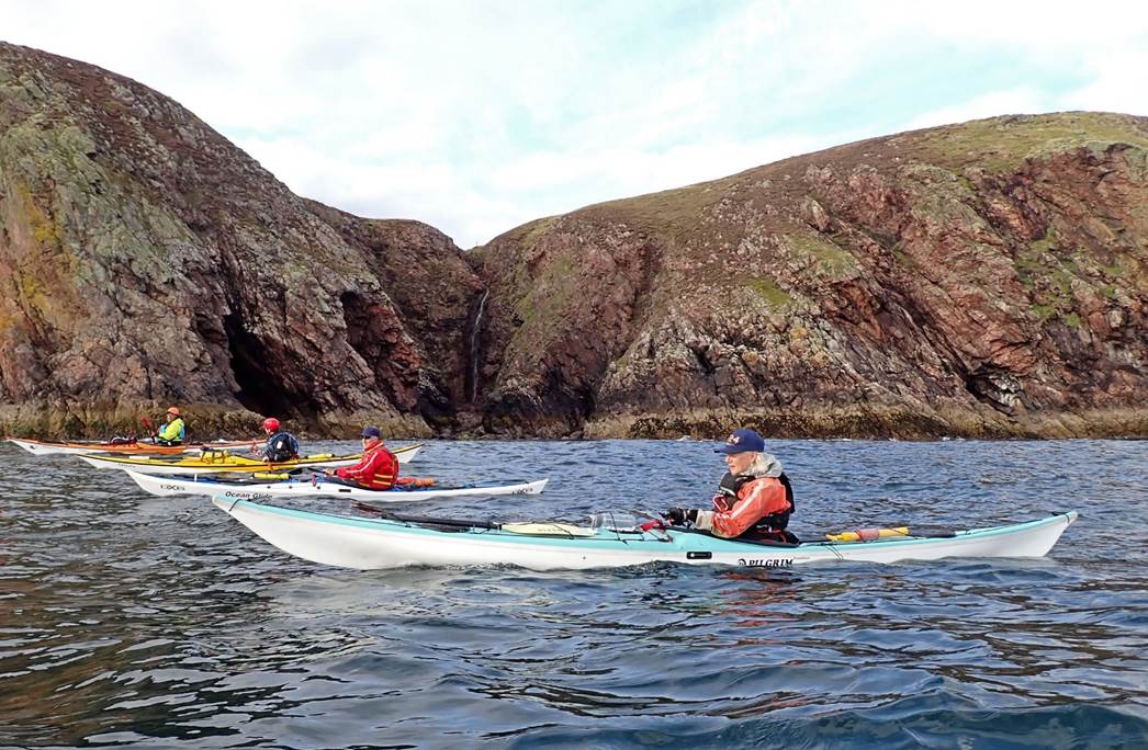 A group of people kayaking on the water

Description automatically generated