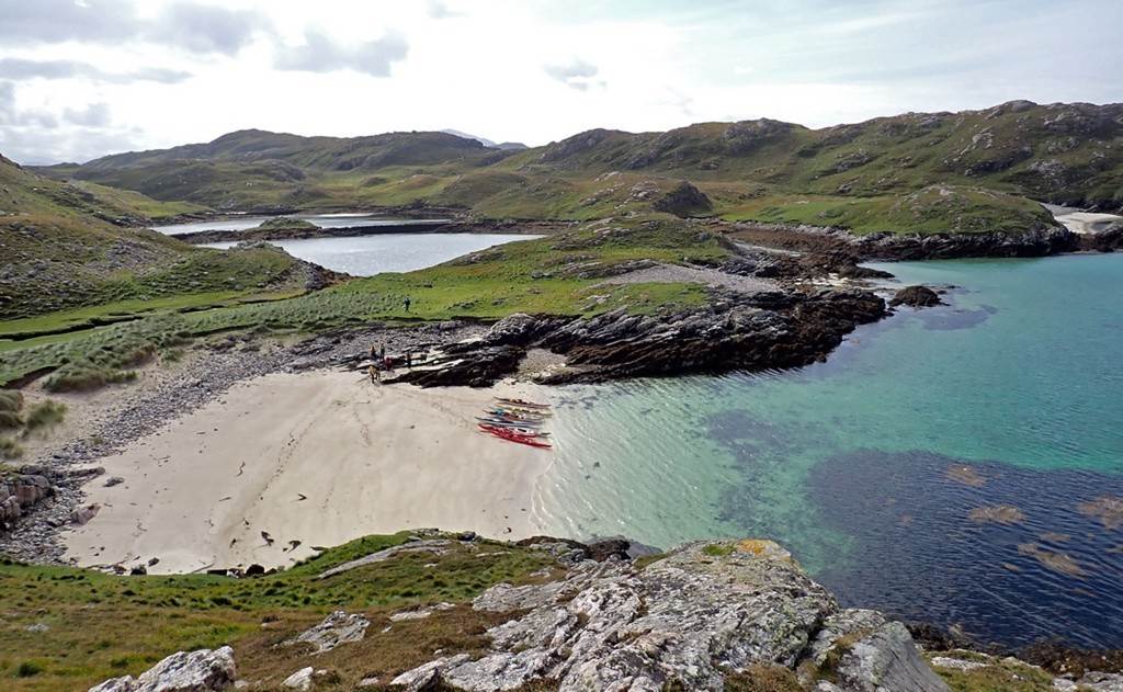 A beach with boats and water

Description automatically generated with medium confidence