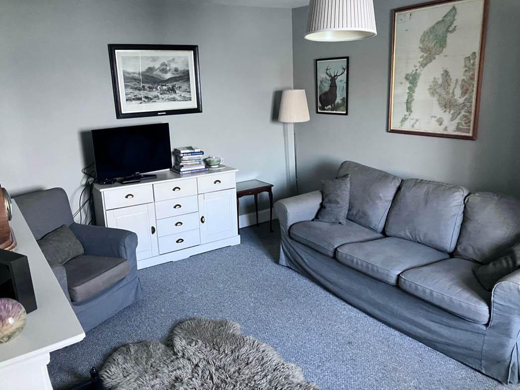 A living room with a couch and a tv

Description automatically generated