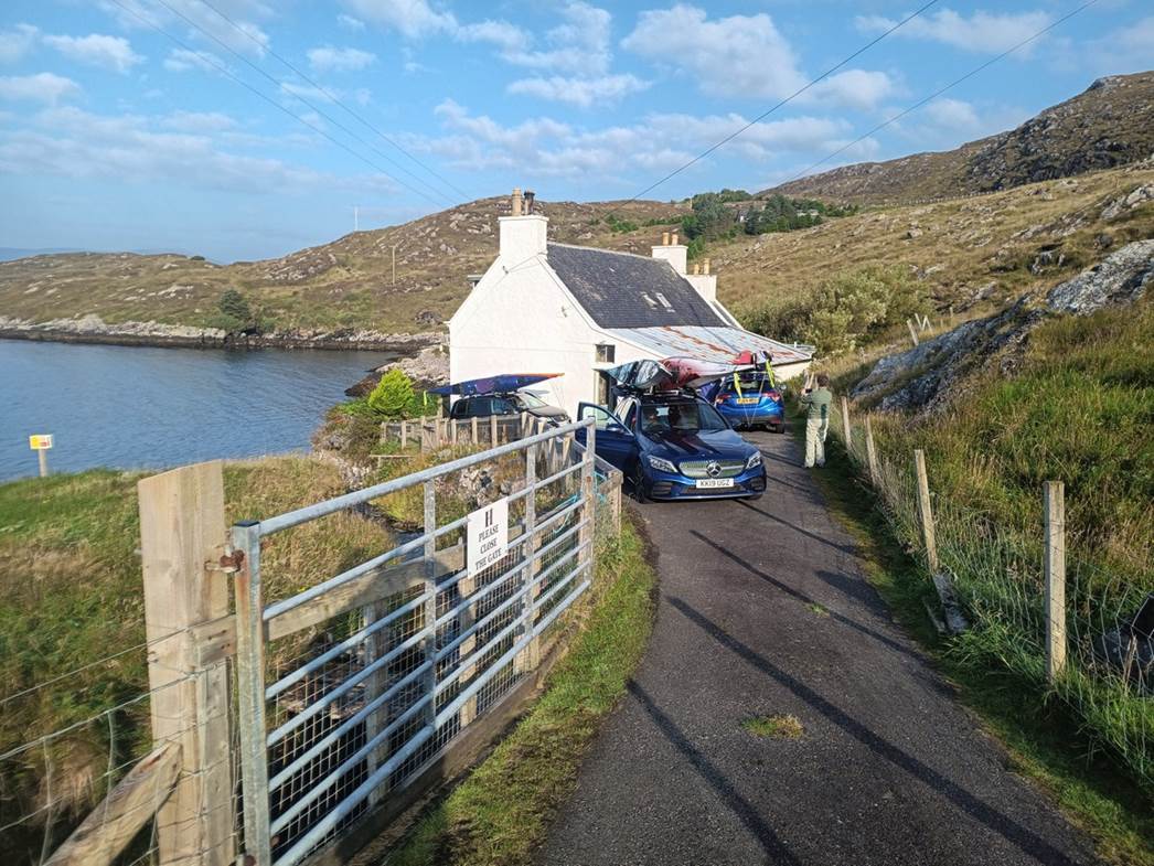 A car parked on a road next to a house

Description automatically generated