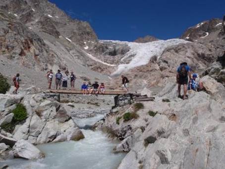 A group of people on a bridge over a river

Description automatically generated