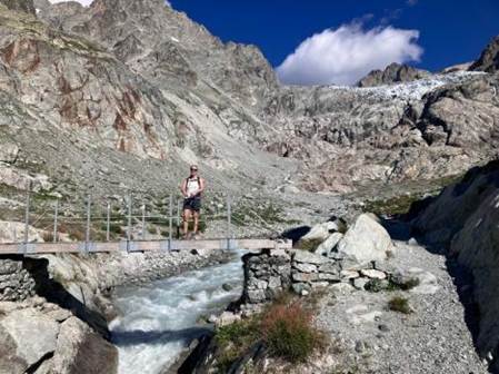 A person standing on a bridge over a river

Description automatically generated