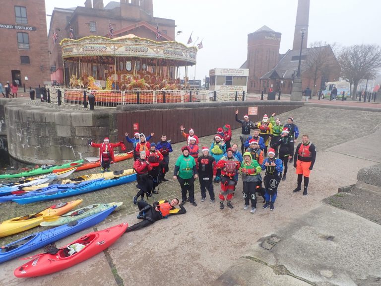 A group of people standing next to a body of water Description automatically generated with low confidence