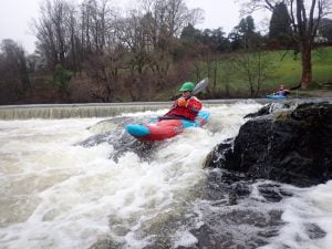 A person in a kayak in a river Description automatically generated with low confidence