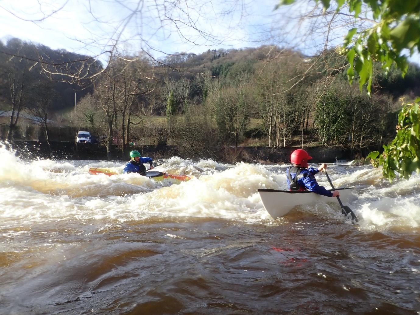 A group of people kayaking in a riverDescription automatically generated with low confidence
