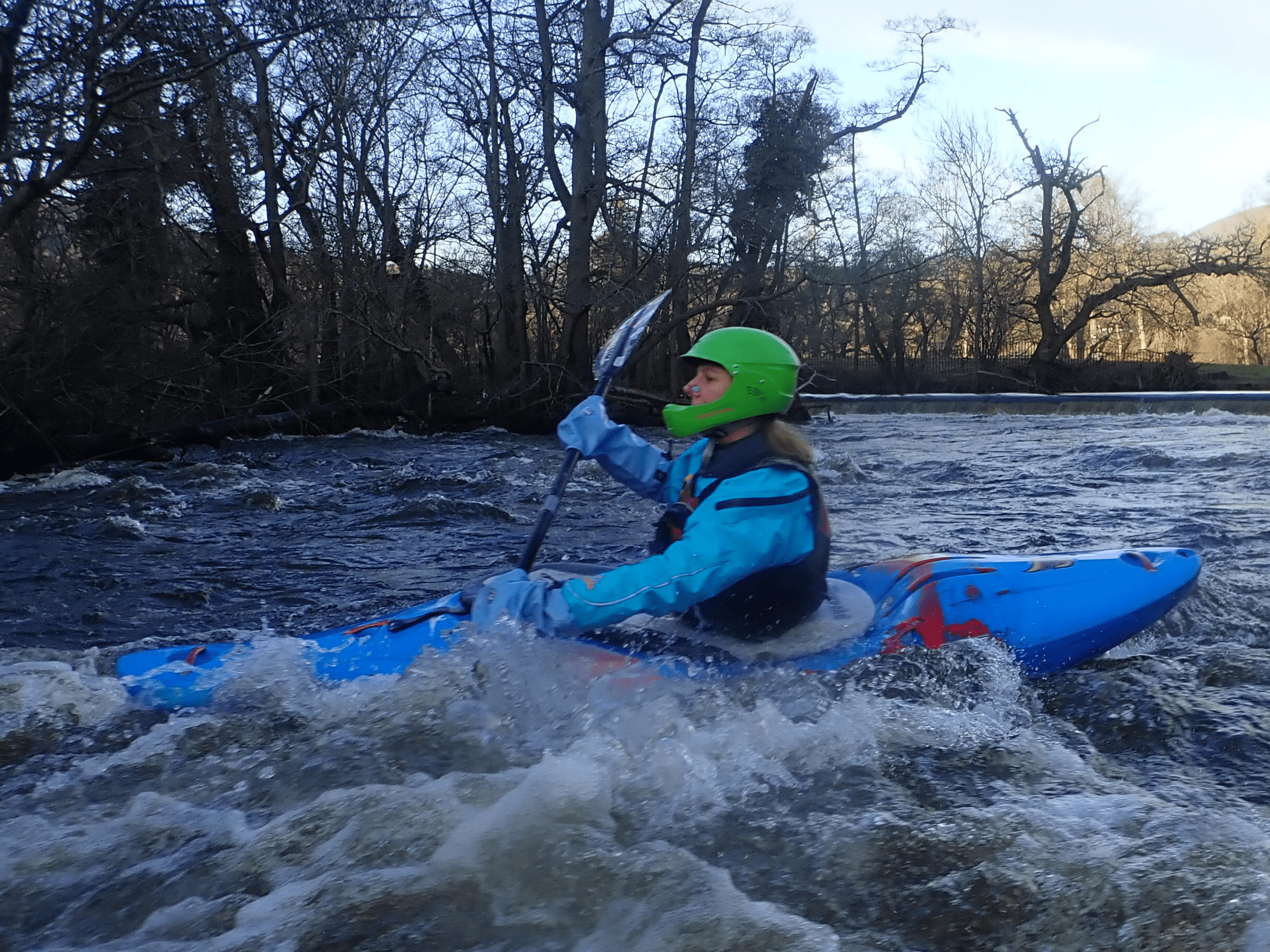 A person in a kayak on a riverDescription automatically generated with low confidence