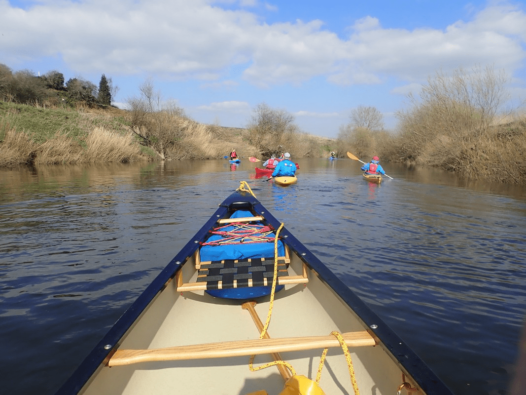 A group of people in a boat on a riverDescription automatically generated with low confidence