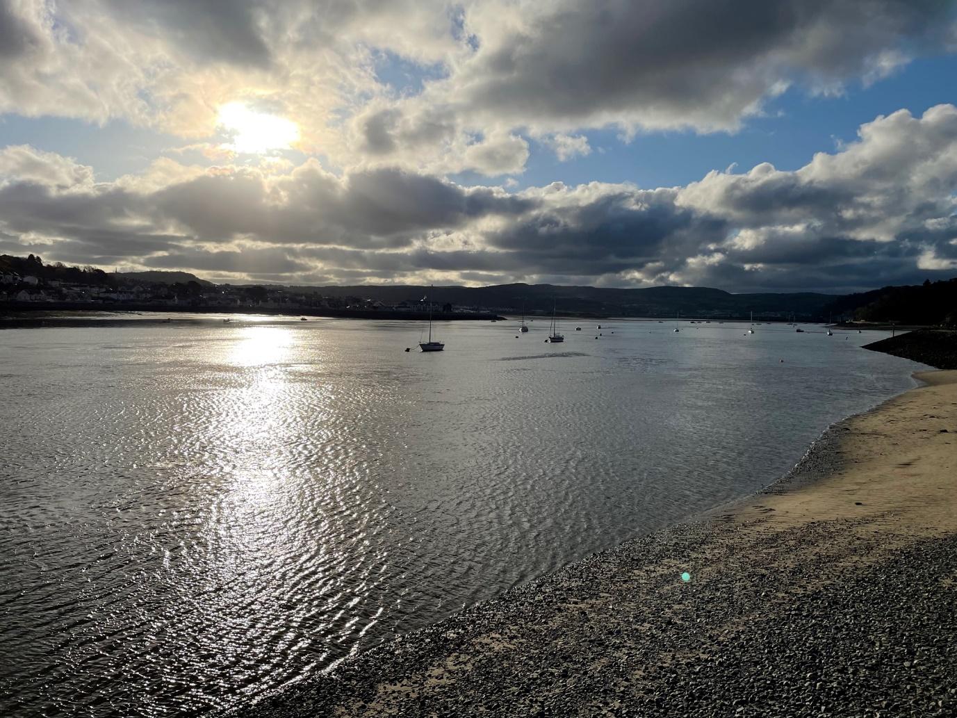 A body of water with boats in it and a cloudy sky aboveDescription automatically generated with medium confidence