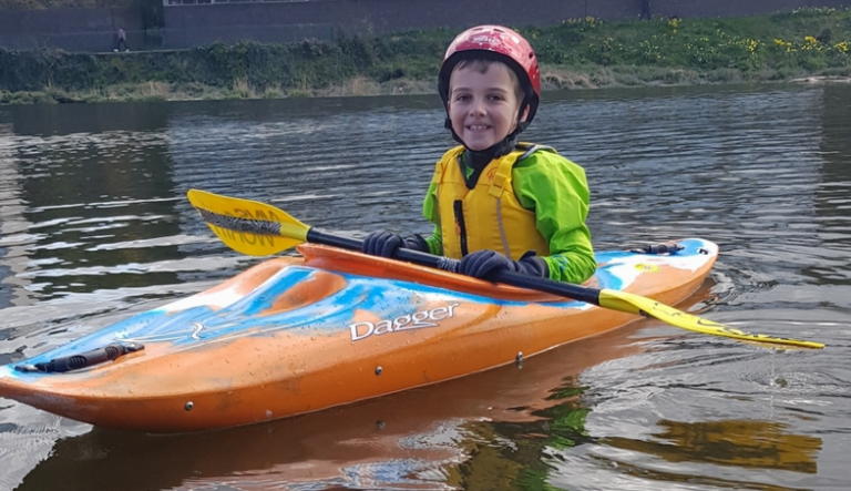 A child in a kayak Description automatically generated with medium confidence