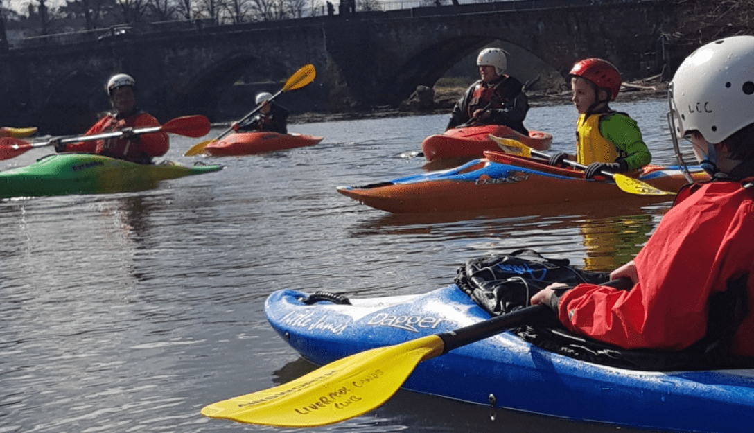 A group of people in kayaksDescription automatically generated with medium confidence