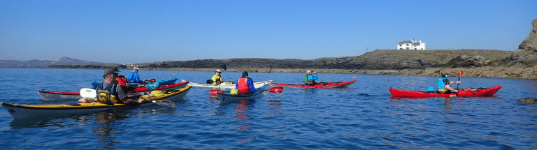 A group of people in kayaks on a lake Description automatically generated with low confidence