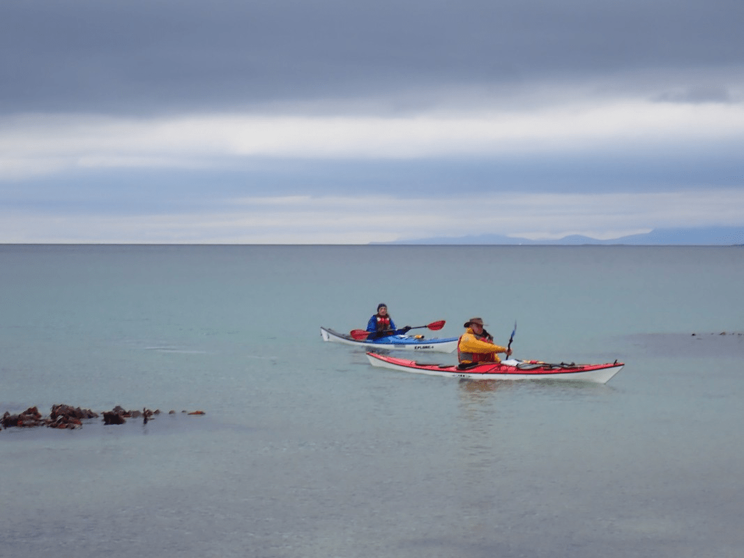 A couple of people in kayaks on a body of waterDescription automatically generated with low confidence