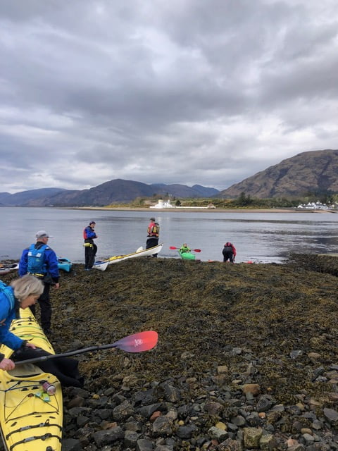 A group of people on a rocky beachDescription automatically generated with medium confidence