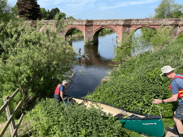 A group of people walking on a bridge over a riverDescription automatically generated with low confidence
